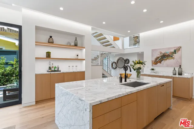 a kitchen with stainless steel appliances granite countertop a sink dishwasher and a stove with wooden floor