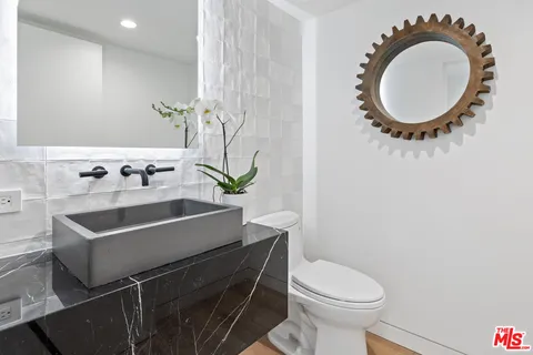 a bathroom with a sink a mirror and toilet