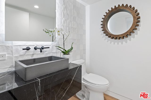 a bathroom with a sink a mirror and toilet