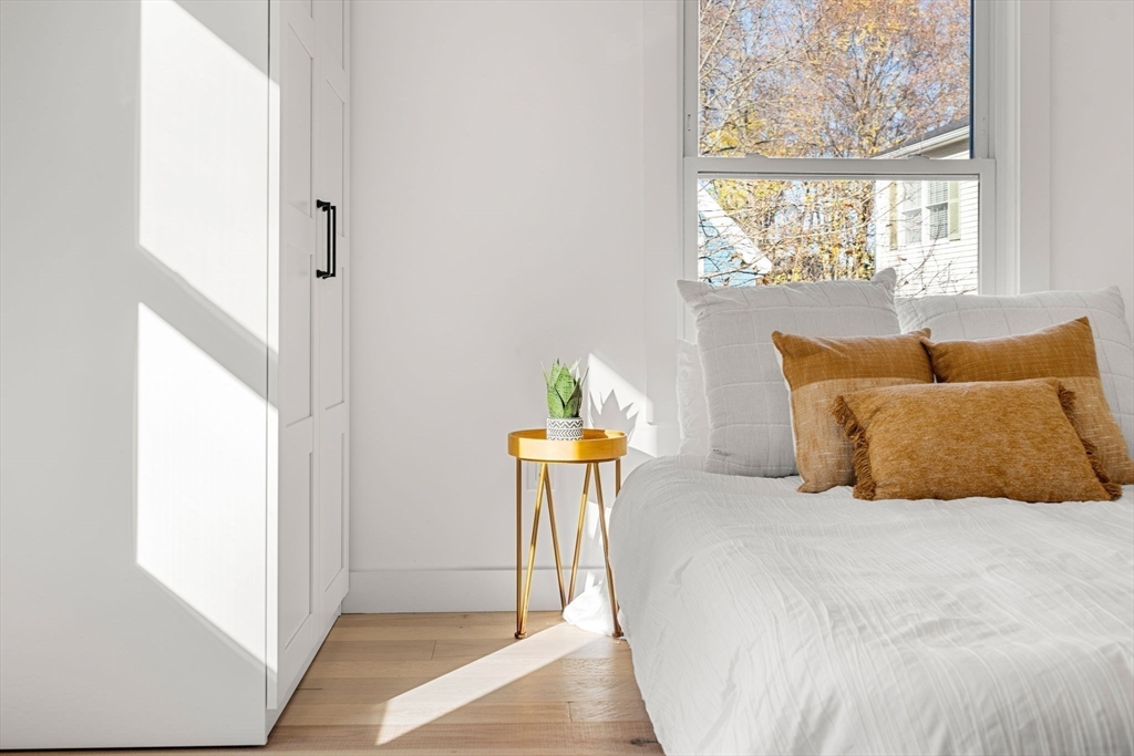 45 Charles Street Wakefield, MA 01880 - Photo 26 of 42 a bedroom with a bed table and a window