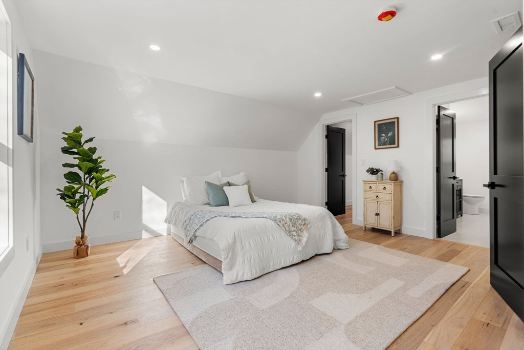 45 Charles Street Wakefield, MA 01880 - Photo 32 of 42 a spacious bedroom with a large bed and a potted plant