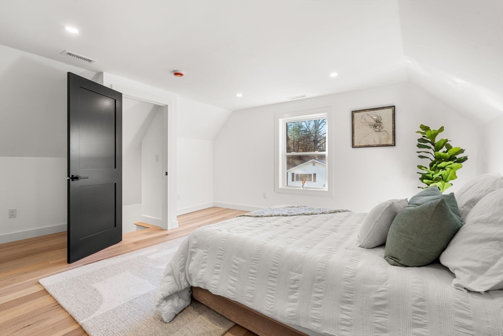 45 Charles Street Wakefield, MA 01880 - Photo 34 of 42 a bedroom with a large bed and a chandelier