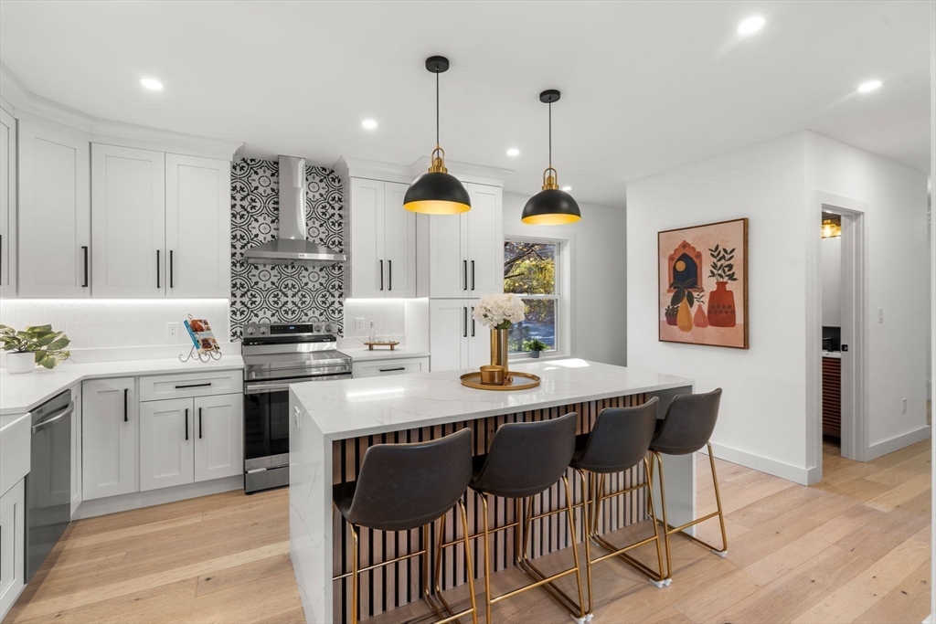 45 Charles Street Wakefield, MA 01880 - Photo 6 of 42 a kitchen with stainless steel appliances granite countertop a sink a stove a dining table and chairs