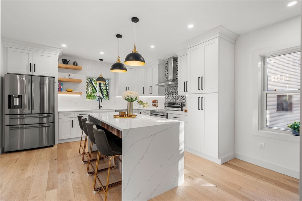 45 Charles Street Wakefield, MA 01880 - Photo 7 of 42 a kitchen with kitchen island a refrigerator a sink a stove a dining table and chairs