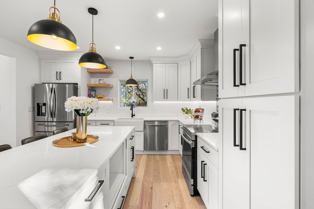 45 Charles Street Wakefield, MA 01880 - Photo 9 of 42 a kitchen with kitchen island granite countertop a sink a stove and refrigerator