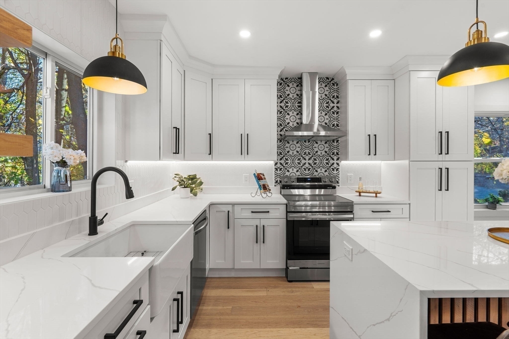 45 Charles Street Wakefield, MA 01880 - Photo 10 of 42 a kitchen with stainless steel appliances a white sink cabinets a stove and a window