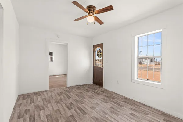 a view of empty room with window and ceiling fan