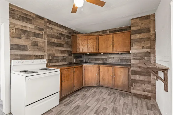 a kitchen with granite countertop a stove top oven sink and cabinets