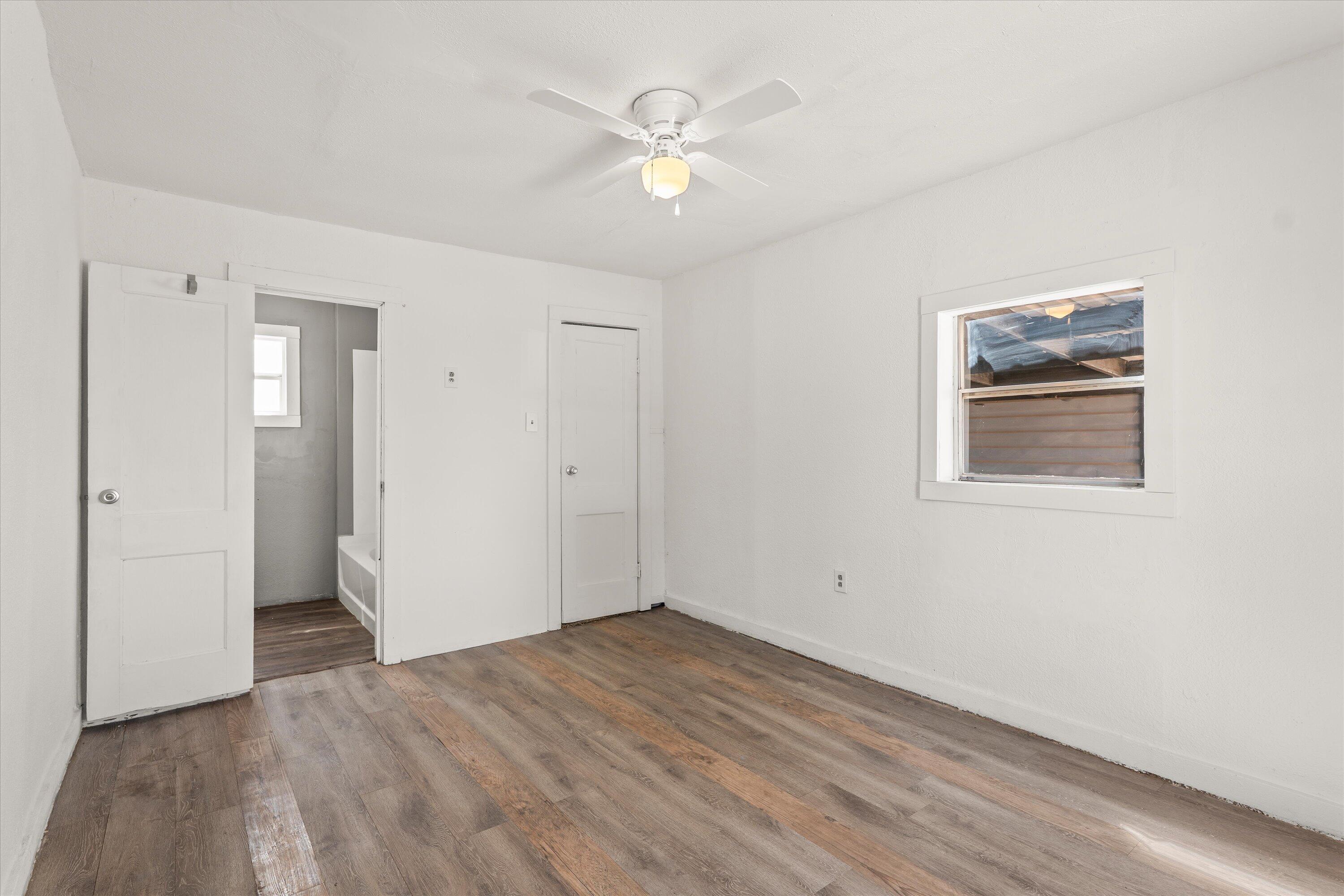 1848 8th Street Levelland, TX 79336 - Photo 4 of 6 wooden floor in an empty room with a window