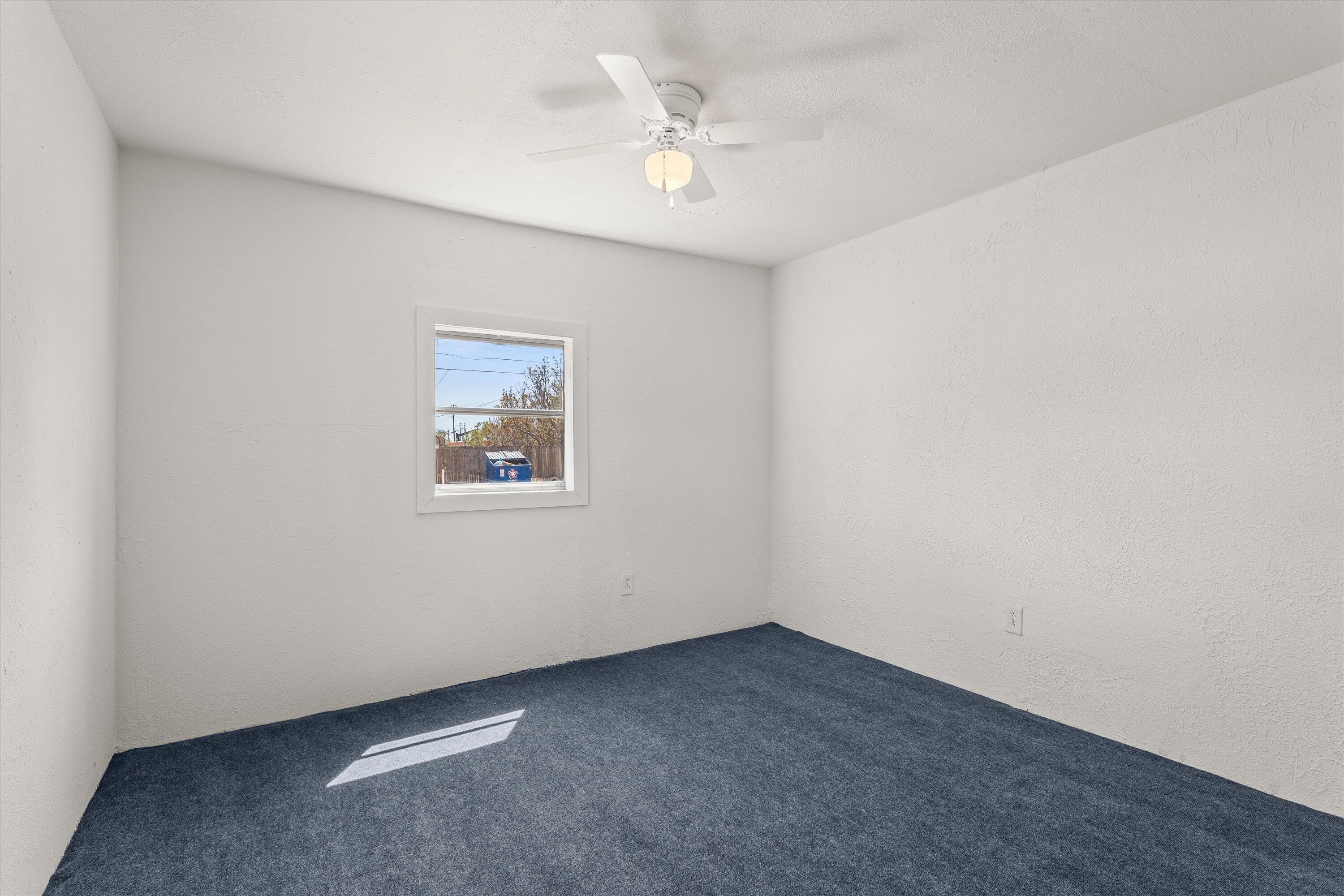1848 8th Street Levelland, TX 79336 - Photo 6 of 6 an empty room with a ceiling fan and window