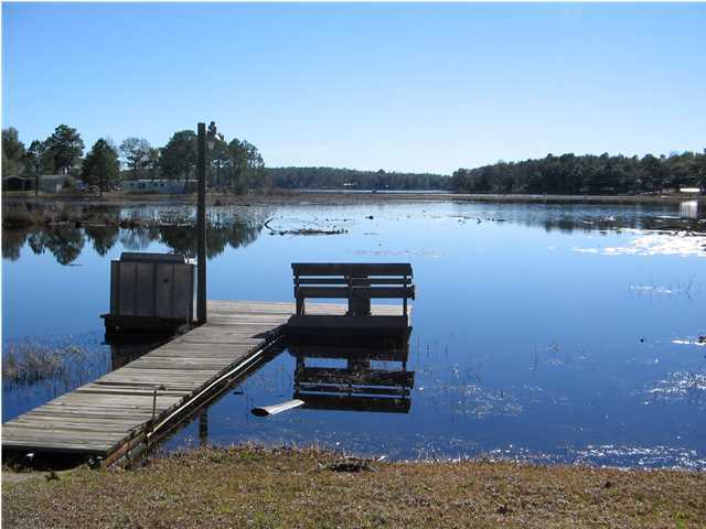 447 Paul Road DeFuniak Springs, FL 32433 - Photo 3 of 15 a view of a lake with wooden stairs and floor