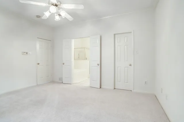 an empty room with a window and a ceiling fan