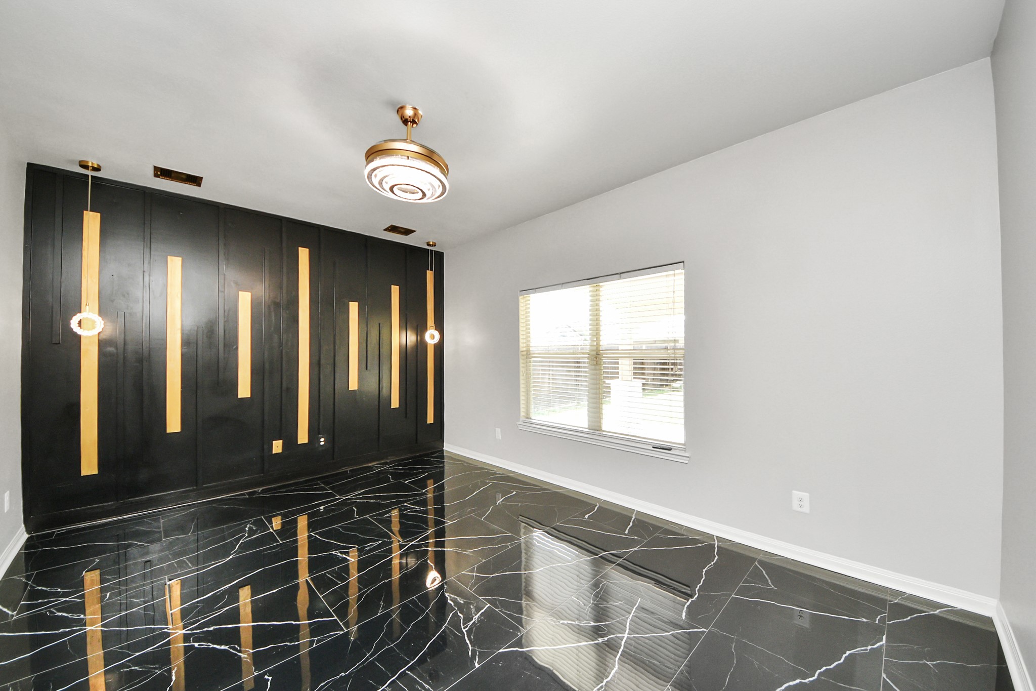 6931 Primrose Road Baytown, TX 77521 - Photo 19 of 50 Spacious primary bedroom with custom accent wall, modern lighting, sleek marble floors, and large window overlooking the backyard.