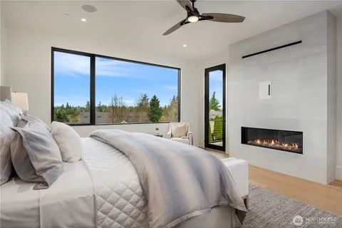 a bedroom with a bed a fireplace and a large window