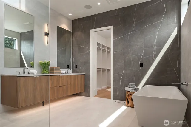 a bathroom with a tub sink and mirror