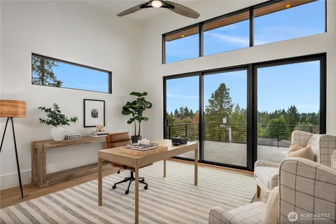 a living room with furniture large window and wooden floor