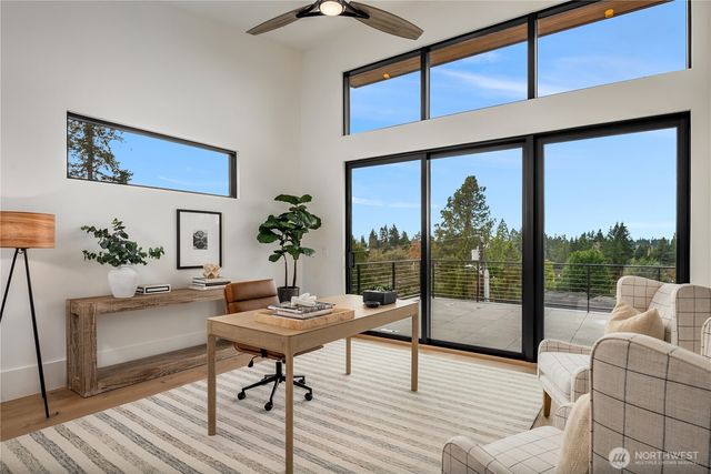 a living room with furniture large window and wooden floor