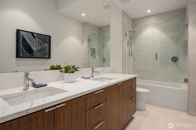 a bathroom with a granite countertop sink a toilet and shower
