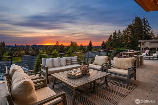 a view of a roof deck with couches and sky view