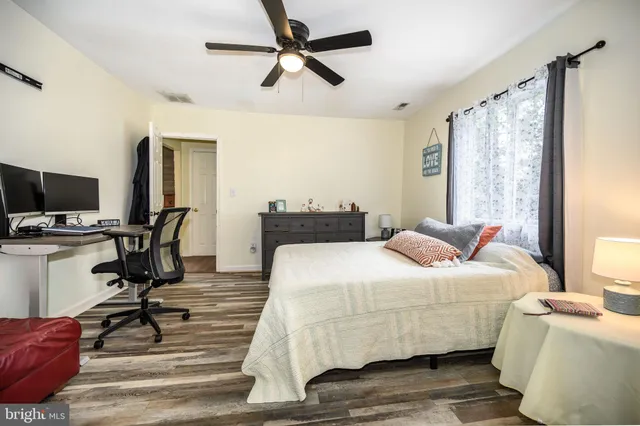 a bedroom with a bed wooden floor and a flat screen tv