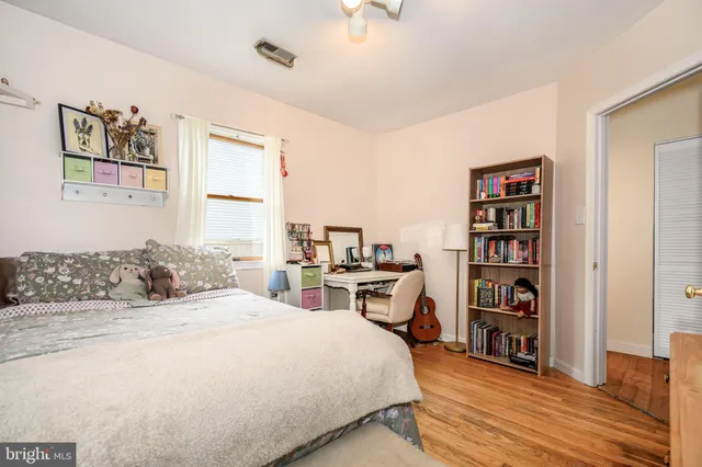 a bedroom with a bed a dresser and book shelf