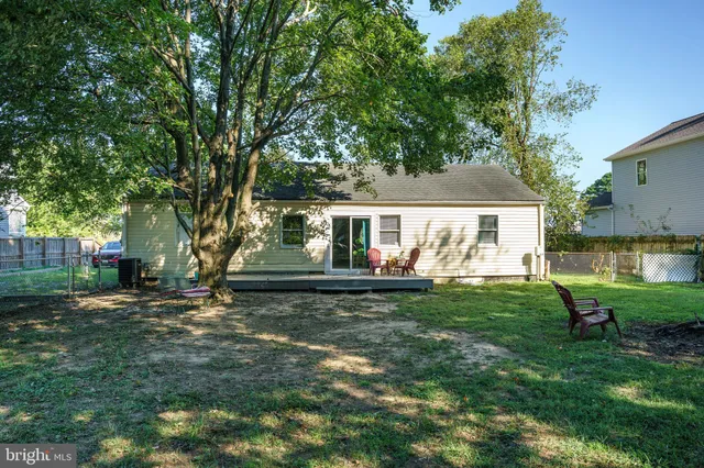 a view of a house with backyard and a tree