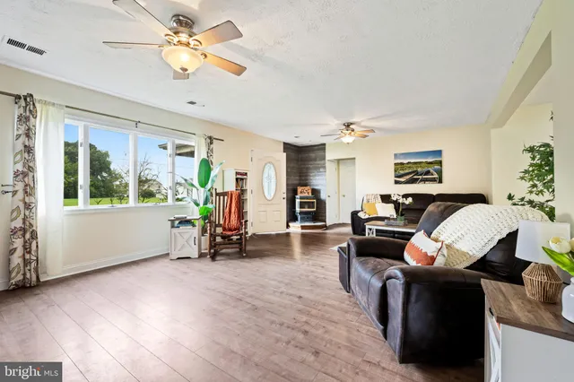 a living room with furniture two window and a chandelier