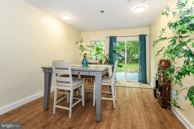 a dining room with furniture potted plants and wooden floor