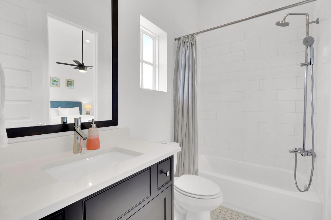 4806 Olive Sparrow Drive, Unit C Austin, TX 78723 - Photo 26 of 32 Bathroom with shower / bath combo with shower curtain, vanity, and ceiling fan