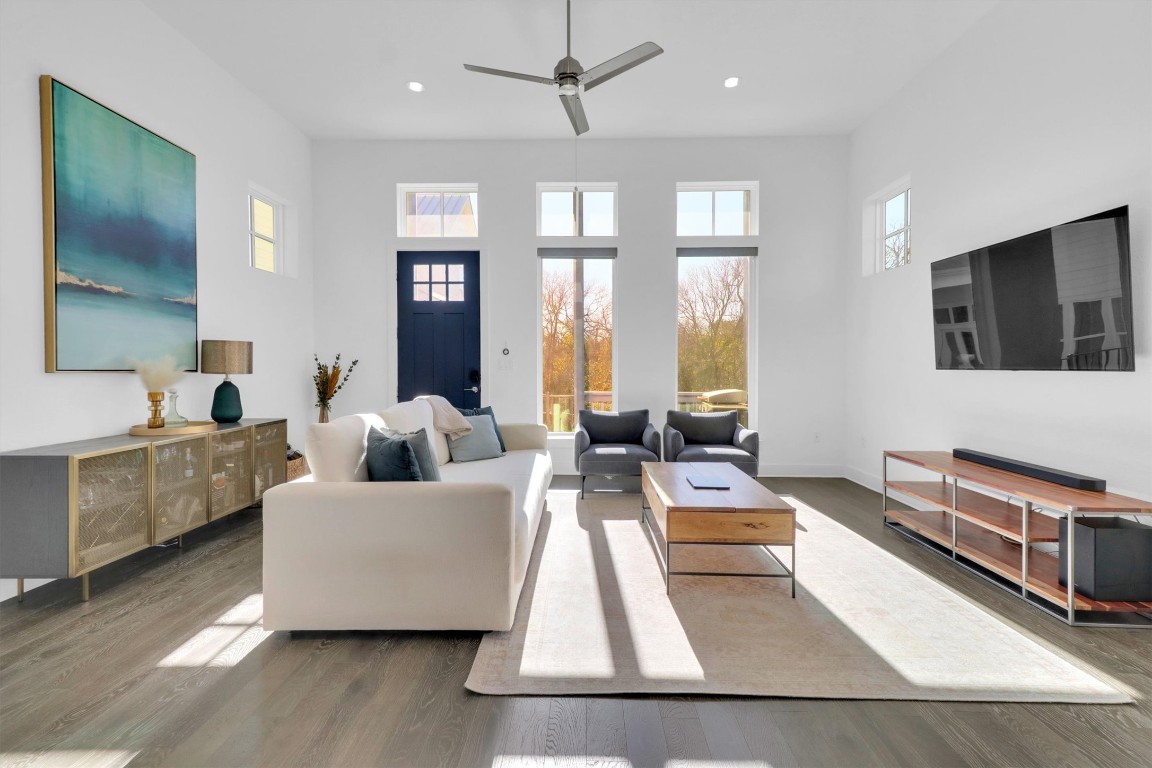 4806 Olive Sparrow Drive, Unit C Austin, TX 78723 - Photo 3 of 32 Living room featuring healthy amount of natural light, wood finished floors, a ceiling fan, a towering ceiling, and recessed lighting