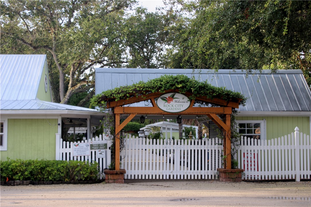 8050 Highway 1 Vero Beach, FL 32967 - Photo 11 of 16 a view of a brick house with a small yard and a wooden fence
