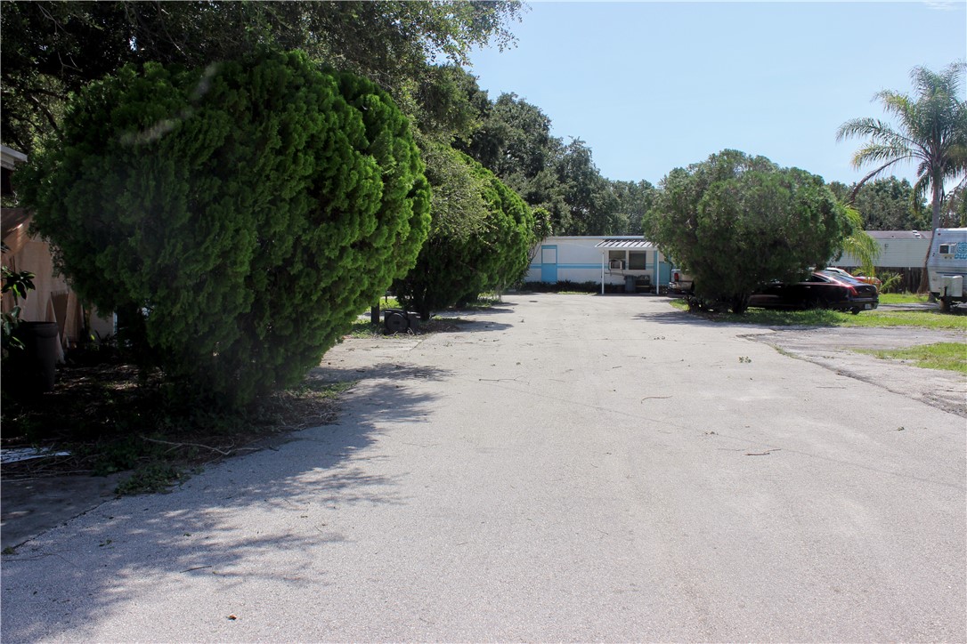 8050 Highway 1 Vero Beach, FL 32967 - Photo 3 of 16 a front view of a house with a yard and tree s