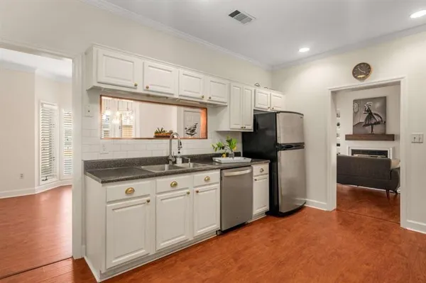 a kitchen with granite countertop a sink stove and refrigerator