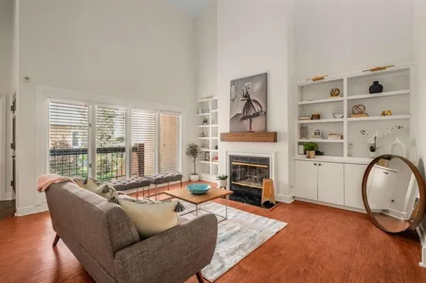 a living room with furniture a fireplace and a large window with rug