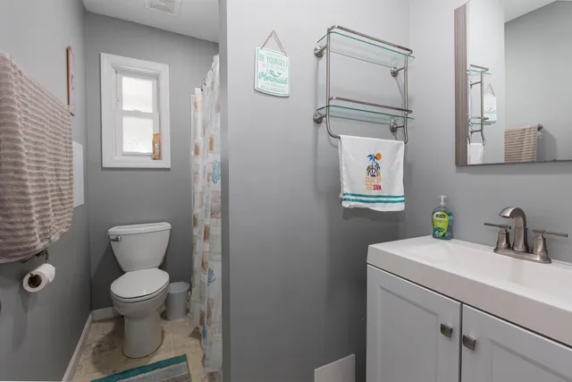 a bathroom with a toilet a sink and mirror