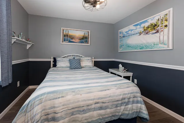 a bedroom with a bed and painting on the wall