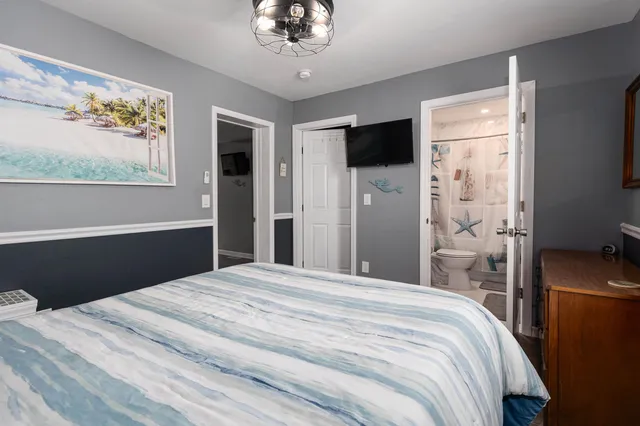 a bedroom with a bed and a flat screen tv