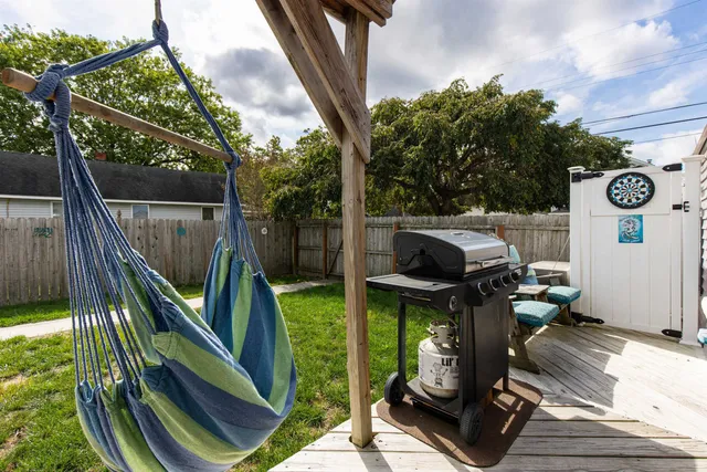 a view of a yard in front of a house with plants and large tree