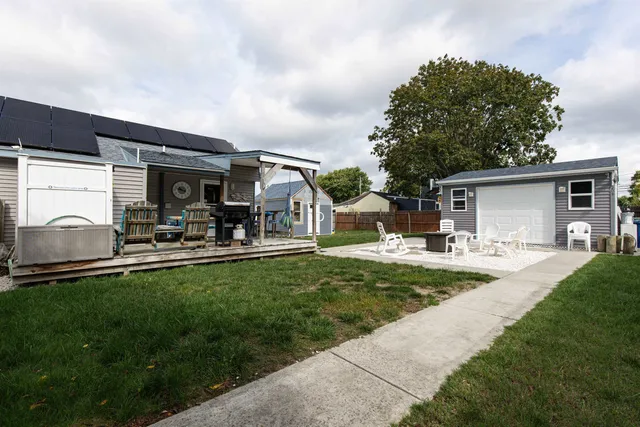 a view of a house with backyard sitting area and garden