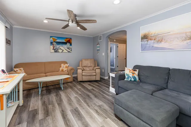 a living room with furniture and a wooden floor