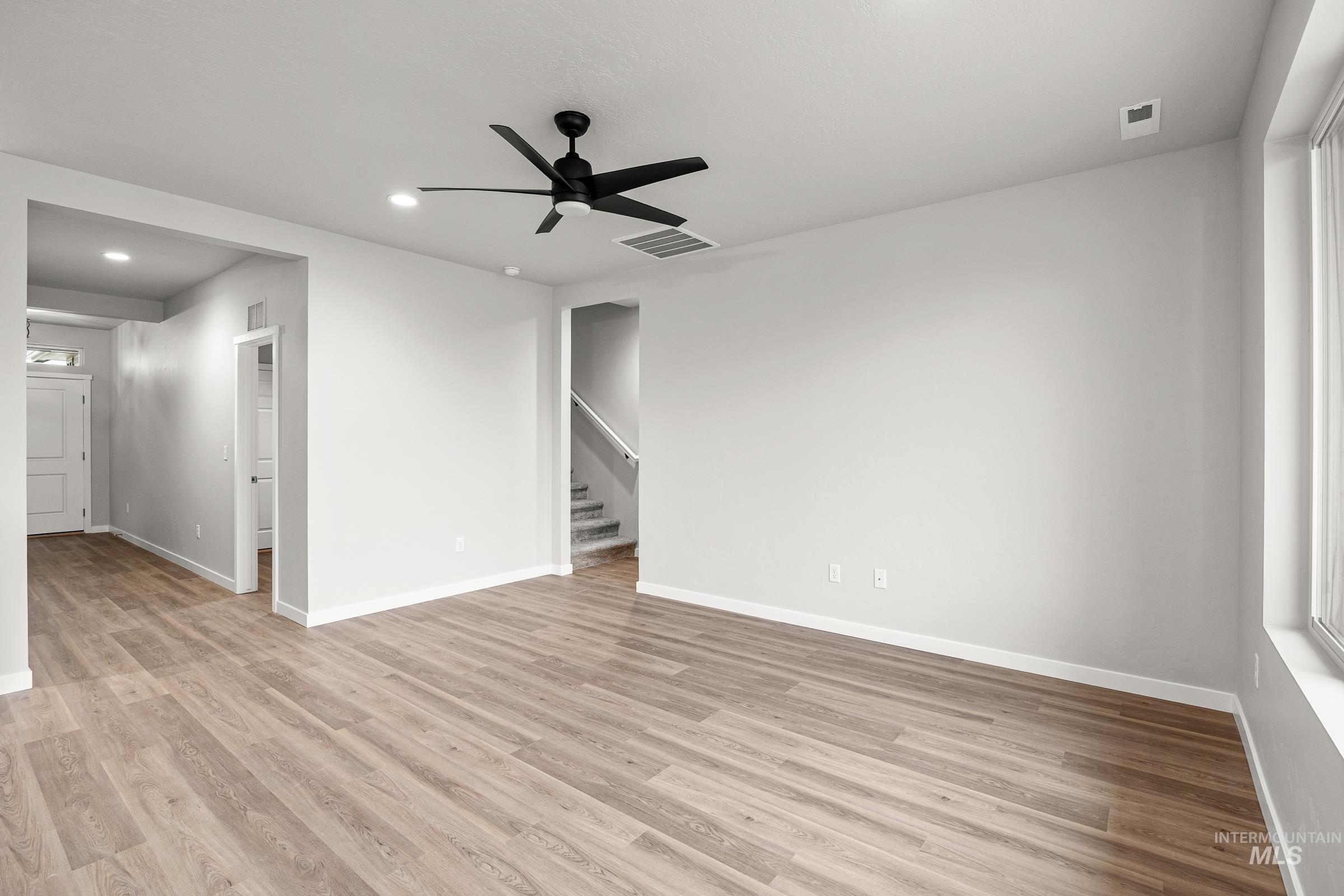 13656 Redway Court Caldwell, ID 83607 - Photo 8 of 21 Open concept room with wood-finish flooring, a contemporary black orb chandelier, and neutral wall tones