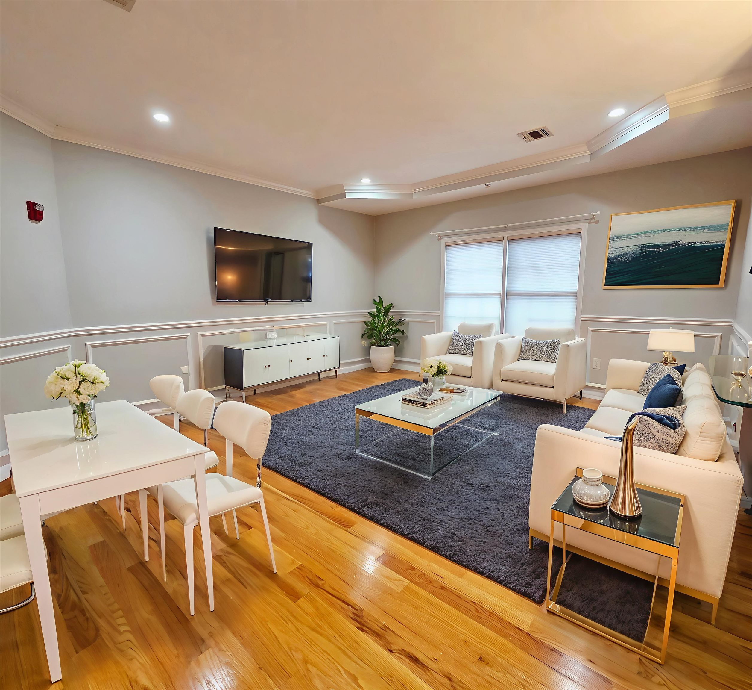 a living room with furniture a flat screen tv and a table