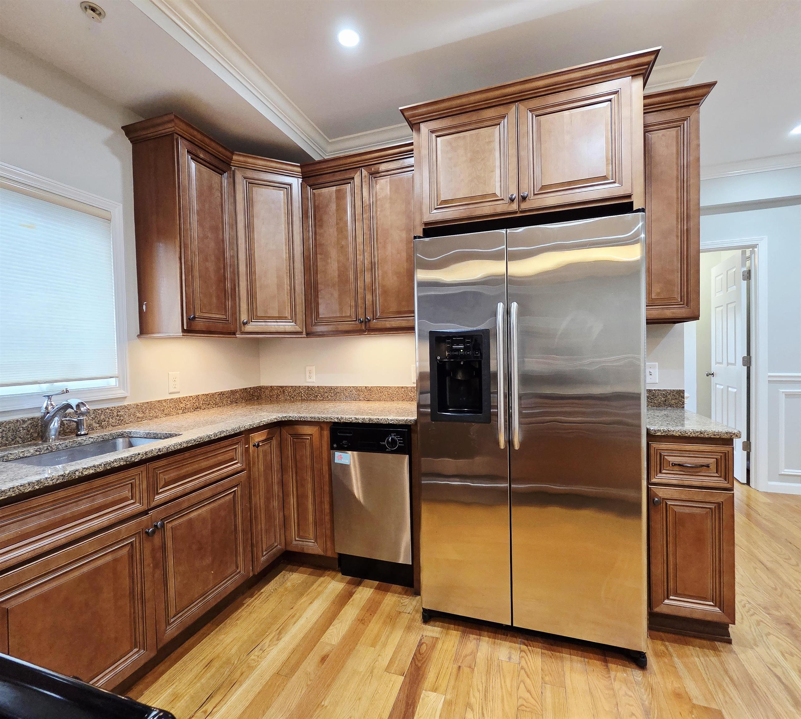 141 68th Street, Unit 7 Guttenberg, NJ 07093 - Photo 3 of 9 a kitchen with granite countertop stainless steel appliances and wooden cabinets