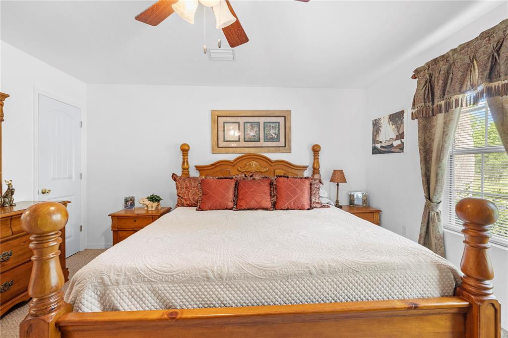 7347 Packingham Drive Webster, FL 33597 - Photo 18 of 75 a bedroom with a bed and a chandelier