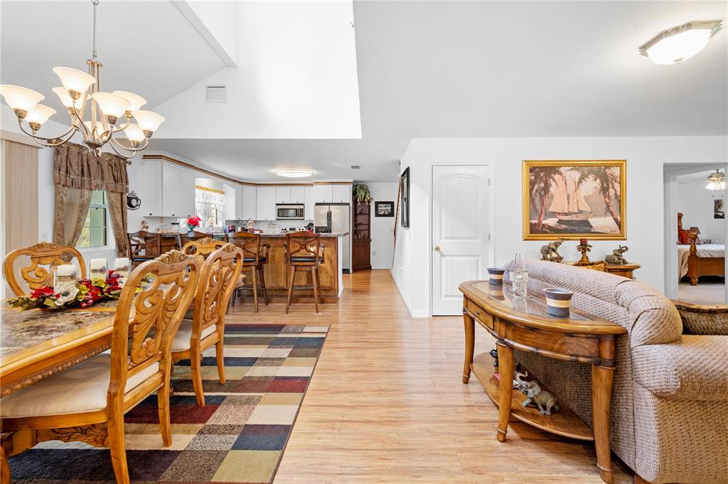 7347 Packingham Drive Webster, FL 33597 - Photo 22 of 75 a living room with furniture a dining table and a chandelier