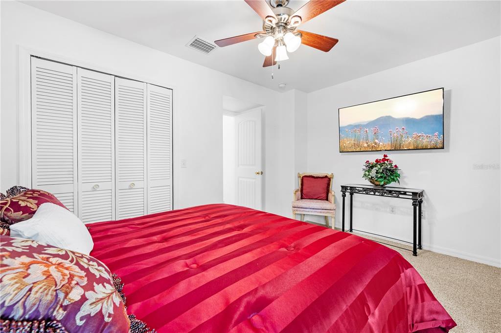 7347 Packingham Drive Webster, FL 33597 - Photo 36 of 75 a bedroom with a large bed and a chandelier
