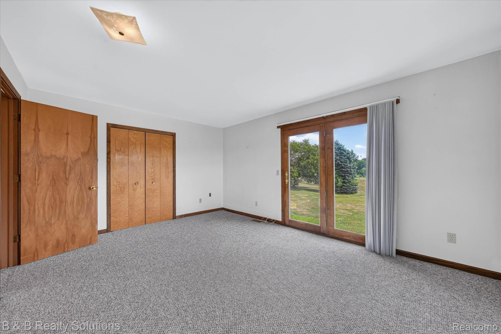 6605 Patrick Road North Branch, MI 48461 - Photo 31 of 44 Sliding glass patio doors, wall-to-wall carpeting, wood-finish interior doors, and a ceiling-mounted light fixture