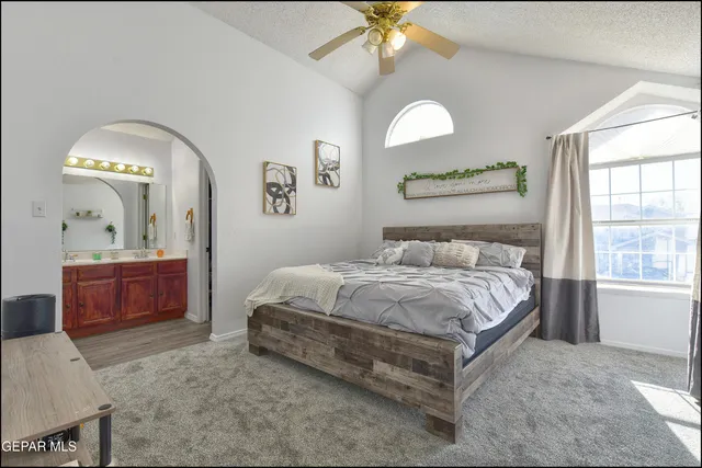 a spacious bedroom with a bed and a dresser
