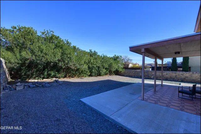 a patio with table and chairs under an umbrella