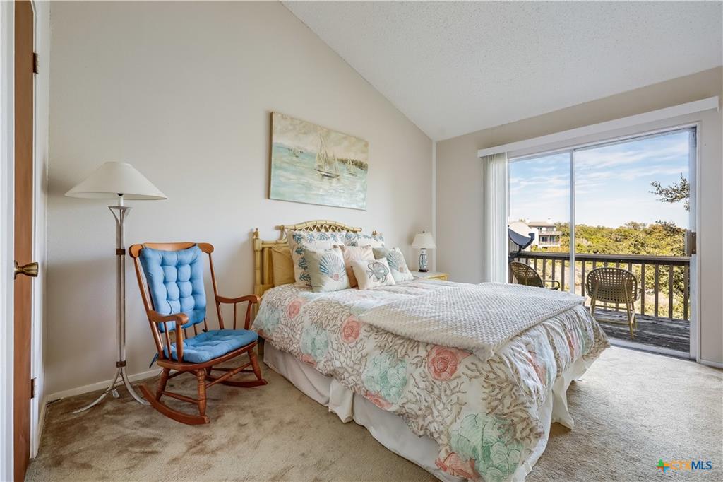 133 Comanche Drive Point Venture, TX 78645 - Photo 20 of 32 a bedroom with a bed a chair and a large window